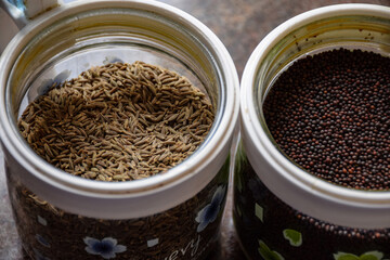 Picture of glass jars or cans used for store cumin seeds and mustard seeds