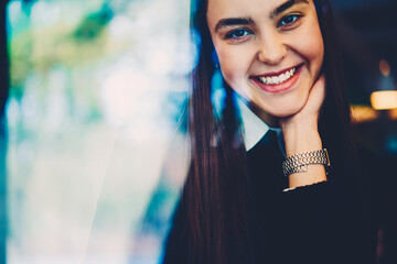 Happy brunette hipster girl resting in cafe interior enjoying free time