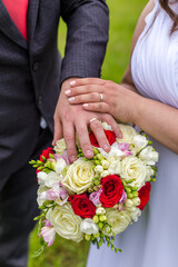 Obraz na płótnie Canvas wedding bouquet and rings with newlyweds