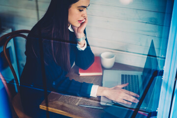 Skilled female copywriter talking on mobile discussing details of task updating application on...