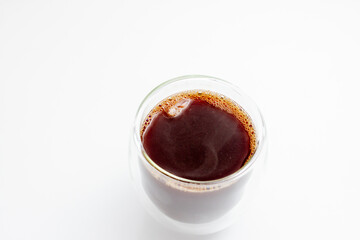 Hot coffee with ice in a glass with double walls on a white background. Selective focus