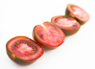 black halves of tomatoes on white background