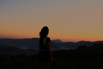 silhouette of a woman standing on the mountain