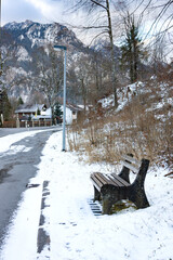 Wooden empty bench against Alps in winter day. Schwangau,