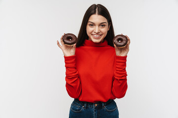 Photo of cheerful brunette woman smiling and holding chocolate donuts