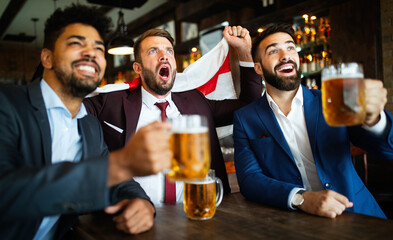 Business men in pub cheering for a sporting event