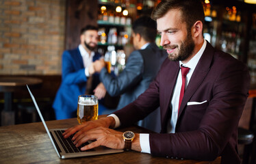 Portrait of a successful business man sitting at the cafe working on a laptop.