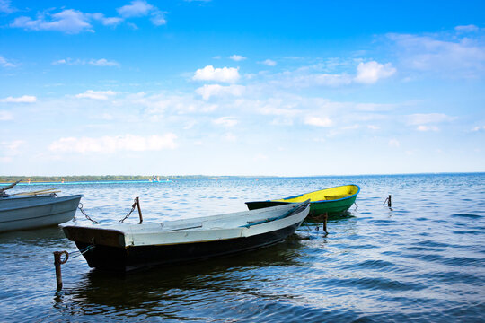 Summer lake and boats. Dramatic sky with clouds.