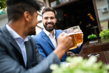 Business people drink beer after work. Businessmen enjoy a beer.