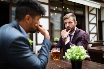 Two sceptical business men talking on a meeting outdoor