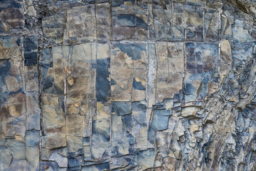Mountain stone. Macro photo. Rough texture of mountain wild stone. Rough surface of an ancient mountain. Grunge texture. Laminated surface. Abstract grunge background. Marble. Granite. 