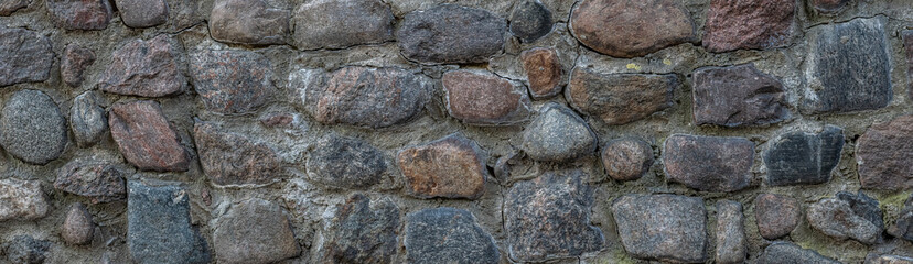 Close Up of wall of granite boulders. panorama of a stone wall. vintage background.