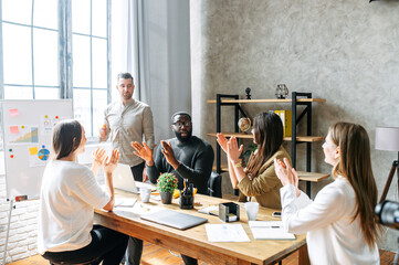 Brainstorming in a multiracial team in office. A young multiracial team appreciate the presentation...