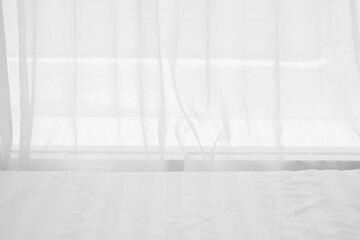 white bed beside see through window curtai