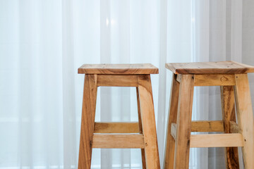 wooden stool chair beside see through window curtain