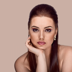 Fototapeta premium Beauty portrait of attractive smiling woman with evening make-up and jewelry earrings