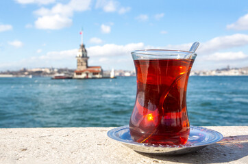 A glass of Turkish tea and bagel against Maidens Tower on sea in Istanbul, Turkey