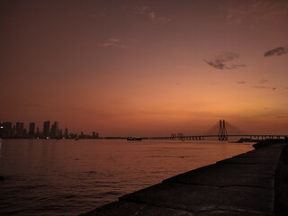Bandra worli sea-link bridge in sea at Bandra, Mumbai with Mumbai's skyline behind it.