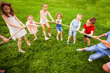 Fototapeta premium Children play with a rope in the park