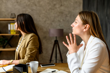 Close-up portrait of women in smart casual clothes. Female coworkers on the morning meeting carefully listening to a speaker