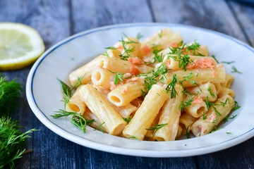  Italian home made  macaroni pasta with smoked salmon , creamy sauce and fresh dill on wooden...