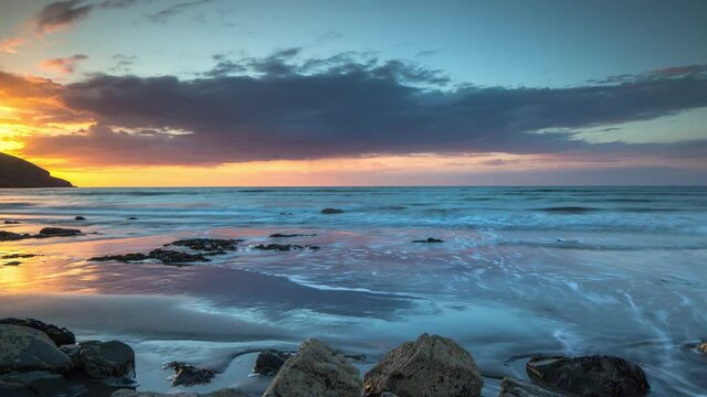 Loopable video of tide coming in and going at sunset filmed in Wales