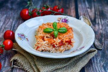 Home made italian oven baked tomato risotto  with a fresh leaf of basil and parmesan cheese 