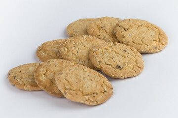 Closeup cereal cookies are arranged in multiple pieces and have three rows, and the cookies are brown and the image has a blank area next to the object and has a white background.