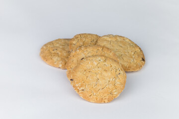 Closeup cookies are arranged in multiple pieces, stacked together, and the cookies are brown and the image has blank space beside the object and has a white background.