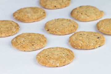 Closeup cereal cookies are arranged in multiple pieces and have three rows, and the cookies are brown and the image has a blank area next to the object and has a white background.
