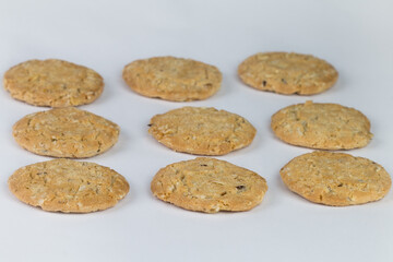 Closeup cereal cookies are arranged in multiple pieces and have three rows, and the cookies are brown and the image has a blank area next to the object and has a white background.