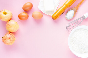 Frame of food ingredients on a pastel pink background. The concept of baking apple pie. Top view, copy space for text.