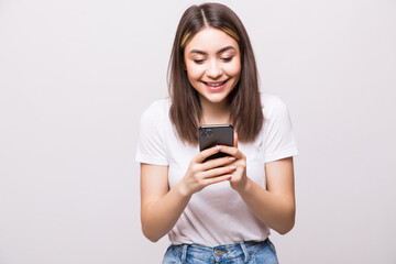 Fototapeta premium Young woman sending a sms on cell phone, isolated on white background