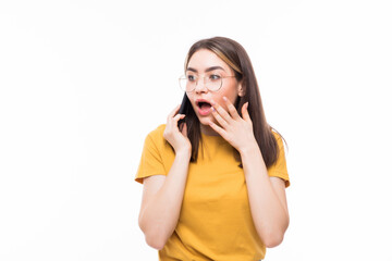 Surprised young woman talking on the mobile phone and pointing finger away isolated on a white background