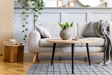 Scandinavian concept of living room interior with design sofa, coffee table, plant in pot, lamp,...