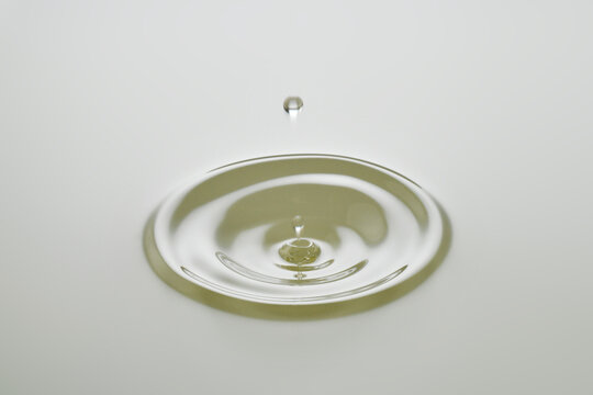 Dripping colorless oil on white background.