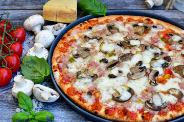  Close up of    hot italian pizza   classic ham. Fresh basil,tomato sauce ,mozzarella cheese , mushrooms and  minced meat .Concept poster for Restaurants or pizzerias. Top view