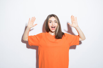 Close-up portrait of surprised beautiful girl holding her head in amazement and open-mouthed over white background.