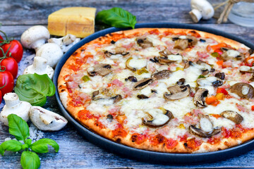  Close up of    hot italian pizza   classic ham. Fresh basil,tomato sauce ,mozzarella cheese , mushrooms and  minced meat .Concept poster for Restaurants or pizzerias. Top view