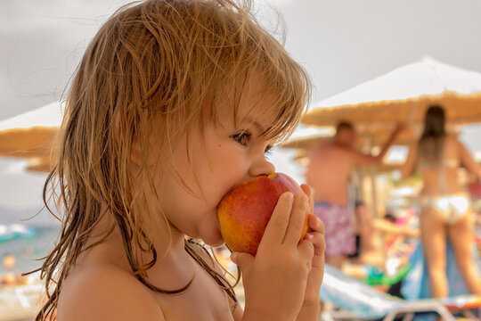 Little Girl Eating A Peach