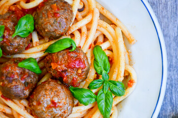 Spaghetti pasta Italian home made meal. Mediterranean food concept .Spaghetti pasta meatballs with tomato sauce, basil, herbs ,parmesan cheese 