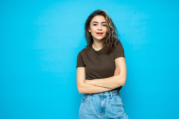 Fototapeta na wymiar Portrait of beautiful cheerful smiling young woman isolated on blue background