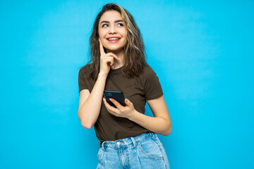 Young smile woman thinking and sending a message over isolated blue background