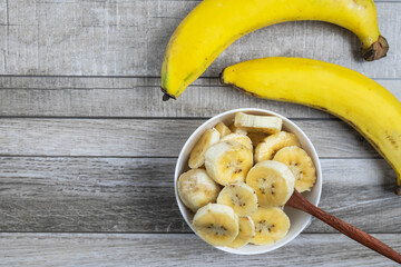 Fresh bananas and bananas cut into pieces in a bowl for health on the table.