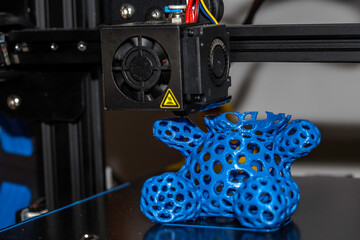 Modern 3D printer printing figure close-up macro.