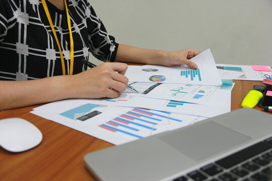 Businesswoman accountant or financial expert analyze business report graph and finance chart at corporate office. Concept of finance economy, banking business and stock market research.