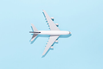 Model airplane on light blue color paper background. Flat lay, top view and copy space for your text