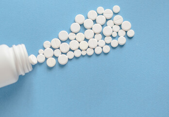 White round pills in a plastic bottle on a blue background for use in presentations, manuals, design, etc. 3D illustration. Medicine concept. top view