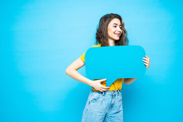 Young smile woman holding a speech bubble on a blue background