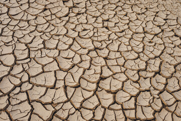 Natural Drought concept:Dried cracked earth soil ground texture background.desert rough land dry crack erosion in the ground due to drought.Dry red clay soil texture, natural floor background
